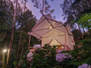 una casa en medio de un jardín con flores en Green Hill Park Ciwidey, en Baruhtunggul