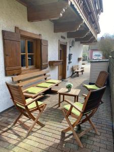 a patio with two chairs and a wooden table at Einzigartiges Alpenstil Chalet mit Panoramablick in Hausen-Wied