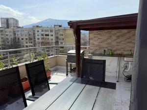 a balcony with a table and a grill on a roof at Apartment near Vitosha mountain, self check-in, with underground parking in Sofia