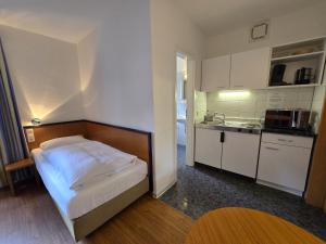 a small bedroom with a bed and a kitchen at Keyless Boardinghouse in Bielefeld +15 photos