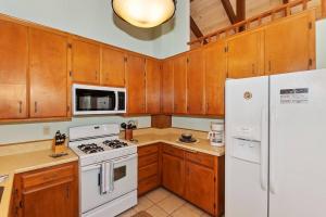 Una cocina con electrodomésticos blancos y gabinetes de madera. en Everwood Serenity Treehouse on Sledding Hill, en Big Bear Lake 30 fotos más