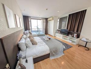 a bedroom with a large bed and a television at Cozy, Spacious 2-Bedder with City, Park View, Near Nana BTS in Bangkok +13 photos