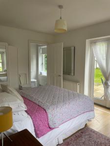 a bedroom with a large bed with a purple blanket at Kerry Country House in Kilteean