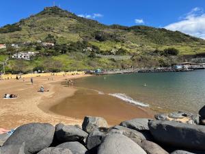 a group of people on a beach with a mountain at House Dino & Telma in Machico