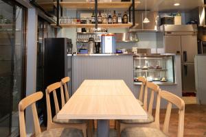 einen Holztisch und Stühle in der Küche in der Unterkunft Juyoh Hotel in Tokio