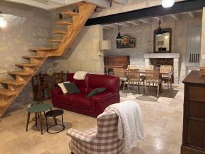 a living room with a red couch and a table at Gîte les Huttières in Cravant-les-Coteaux