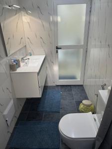 a bathroom with a toilet and a sink and a shower at Appartement Somone , Sall Residence in Mbour