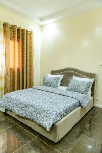 a bedroom with a large bed with blue sheets and pillows at Appartement Somone , Sall Residence in Mbour