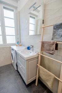 a bathroom with a sink and a washing machine at Eta - apartman u centru grada in Pula