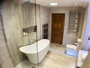 a bathroom with a large white tub and a toilet at Luxury Cosy Cottage in Criccieth +15 photos