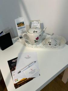 a white table with a tea pot and a book at Sicilia nel Cuore Apartment in Cassibile