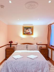 une chambre avec un lit avec deux serviettes dessus dans l'établissement Europa House Hotel, London Paddington, à Londres