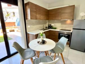 a kitchen with a table and chairs and a refrigerator at Blue dream in Nikiana