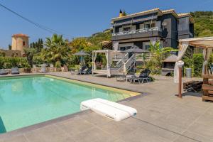 a swimming pool in front of a house at Semeli Art House 2 in EFL