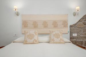 une chambre avec un lit blanc avec deux oreillers dans l'établissement Nott'e Die, à Olbia