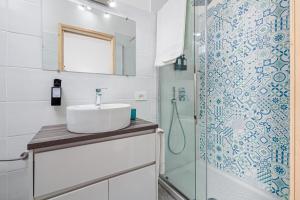 une salle de bain avec un lavabo et une douche dans l'établissement Nott'e Die, à Olbia