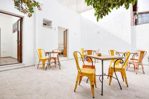 un patio avec tables et chaises dans un bâtiment dans l'établissement Nott'e Die, à Olbia