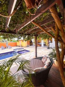 un patio con una silla de mimbre bajo una pérgola en CHACARA da LARY, en Pirenópolis