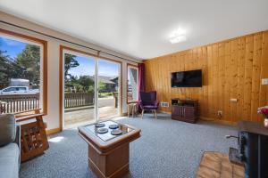 a living room with a couch and a tv at Cottage By The Sea Nedonna Beach Getaway in Rockaway Beach