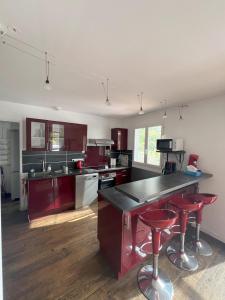 a kitchen with a counter and red stools in it at Punta di l'Ortu House in Conca