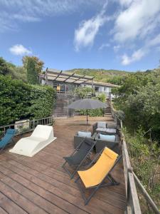 a wooden deck with chairs and an umbrella at Punta di l'Ortu House in Conca