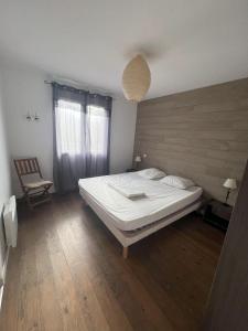 a bedroom with a large bed and a chair at Punta di l'Ortu House in Conca