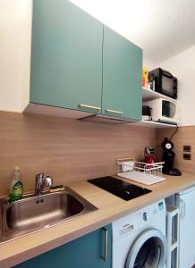 eine Küche mit Spüle und Waschmaschine in der Unterkunft Hesperie studio in Chamalières + 3 Fotos