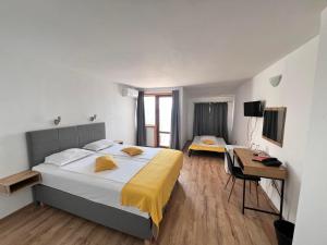 a bedroom with a bed and a desk and a television at Palma Beach Hotel in Kranevo