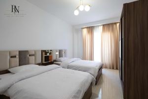 1 Schlafzimmer mit 3 Betten und einem Fenster in der Unterkunft Spacious 2 BDR Apartment In Rehab City in Burg el-Ḥudûd