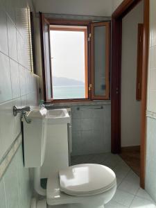 a bathroom with a white toilet and a window at Finestra sul golfo in Balestrate +18 photos