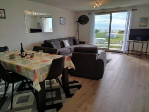 a living room with a table and a couch at les Dunes in Jullouville-les-Pins