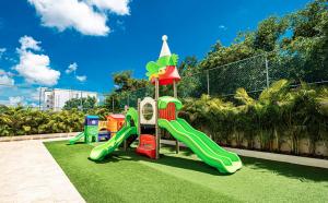 a playground with a slide on the grass at Depa boutique nuevo de 2 recámaras - diseño, confort y excelente ubicación con alberca in Playa del Carmen