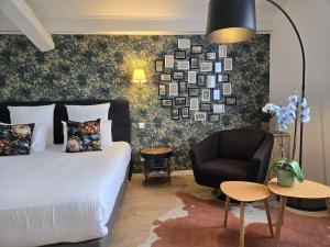 a hotel room with a bed and a chair at Hôtel Le SAINT-GENIÈS in Uzès