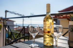 a bottle of wine sitting on a table with two wine glasses at Jella's sunny apartment in Nea Skioni +27 photos