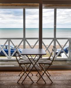 una mesa y una silla frente a la playa en Little Hampton Beach House, en Herne Bay 11 fotos más