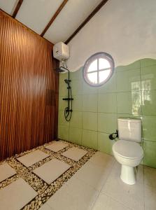 a bathroom with a toilet and a window at Satha private villa Dieng 3 in Banjarnegara +15 photos