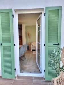 a door leading into a living room with green shutters at Düne 4 - Ferienunterkunft mit eigenem Garten in der beliebten Dünenresidenz - sanftes Meeresrauschen inklusive in Karlshagen