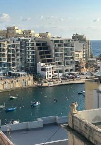 a view of a city with boats in the water at Cherry Penthouse in Spinola Bay in St. Julianʼs