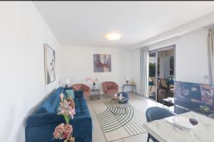 a living room with a blue couch and a table at Sea Satin Villas - Ayia Napa Center in Ayia Napa