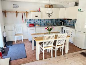 a kitchen with white cabinets and a wooden table and chairs at VasaLodge Sälen in Sälen