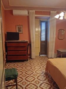 a bedroom with a bed and a desk and a door at Casa Dei Greci in Patti +35 photos