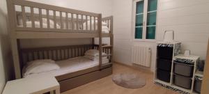 a bedroom with a bunk bed with white walls at La forestière avec Jacuzzi pour 6 personnes in Saint-Georges-dʼOléron