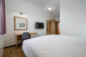 a bedroom with a bed and a desk and a television at Holiday house Lera Rovinj, with football field, sauna, jacuzzi in Rovinj