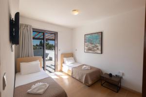 a hotel room with two beds and a balcony at Sea Satin Villas - Ayia Napa Center in Ayia Napa +70 photos