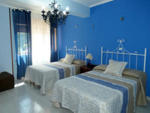 1 dormitorio con 2 camas y paredes azules en Casa Daniel, en Riberas del Sor