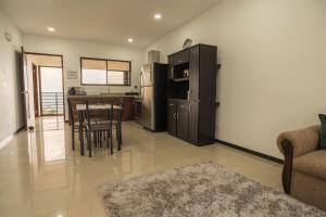a kitchen and living room with a table and a refrigerator at Volcan Hule Lodging in Río Cuarto