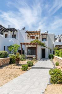 ein weißes Haus mit einem Gehweg davor in der Unterkunft Villa Sunrise by the Sea in Kiotari