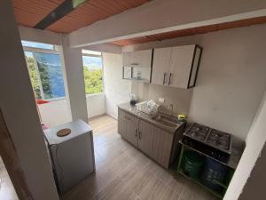 Una pequeña cocina con fregadero y estufa. en apartamento campestre 201, en Ibagué