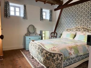 a bedroom with a bed with a dresser and a mirror at Maison des Roses in Saint-Savinien
