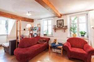 a living room with two chairs and a red couch at Cosy & Historic Ambience in Markt Nordheim